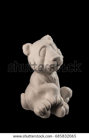 White plaster statuette figurine toy tiger on a black background
