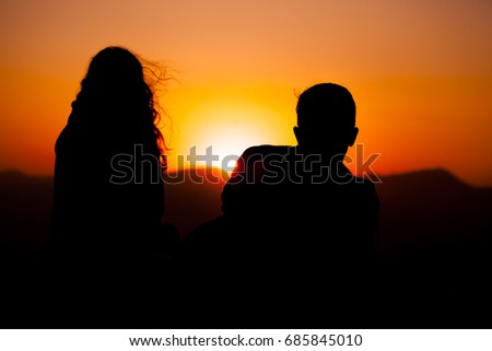 Silhouetted loving couple at sunset