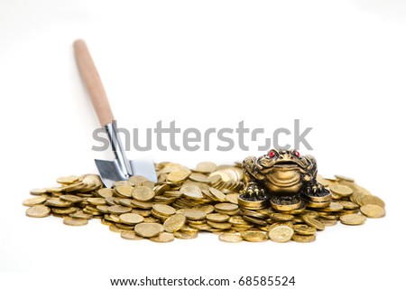 Feng Shui Frog sitting on the heap of  coins with shovel near by