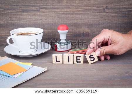 lies. Wooden letters on dark background