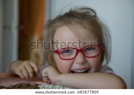 Little girl with red glasses and money box.