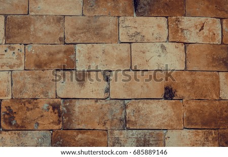 Old brown brick wall with cracks and scratches. Horizontal wide brickwall background. Distressed wall with broken bricks texture. Vintage house facade.