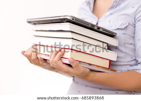 Education concept. Woman holding pile of books and laptop