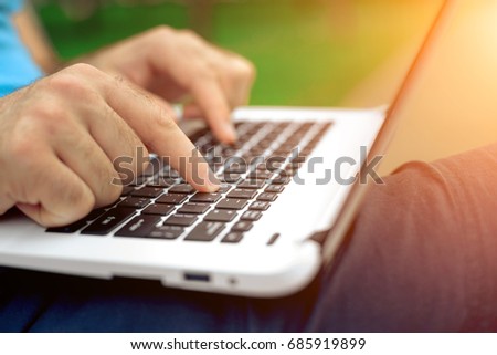 Close-up shot of handsome man's hands touching laptop computer's screen.