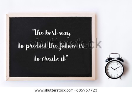 Motivational quote to create future on nature abstract chalkboard and alarm clock. The best way to predict the future is to create it.