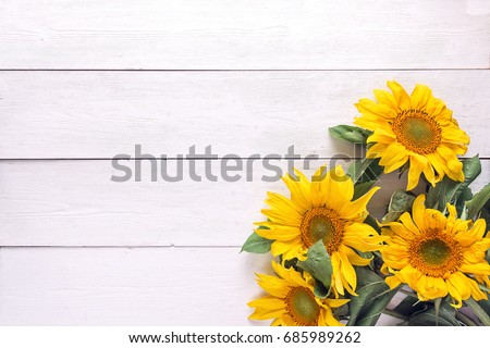 Background with a bouquet of yellow sunflowers on  white painted wooden planks. Space for text. Top view.