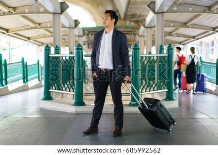 Business traveler pulling suitcase.