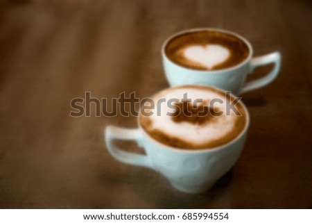 Blurry two white cup of coffee on wooden table. Blurry background
