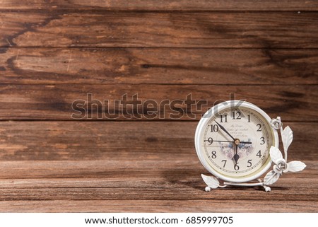 The clock on wooden background.