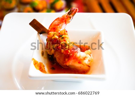 Orange shrimp on a white plate at a mini cocktail party