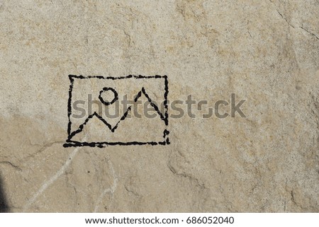 Doodle drawn on rock texture showing picture icon