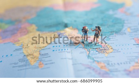 Travel Concepts. A little figure couple backpacker or miniature couple tourist male and female stand and walk on map of Thailand in world map. Royalty-Free Stock Photo #686099905
