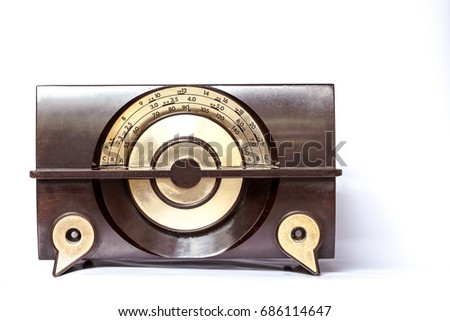 A classic AM-frequency radio, is in brown color with golden round dial design. This vintage style radio includes frequency tuning and volume knobs on each corner of the cabinet.