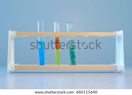 Three test tubes, containing (left to right) a precipitate of copper hydroxide, a precipitate of iron (III) hydroxide, and the third a precipitate of iron (II) hydroxide. Royalty-Free Stock Photo #686115640