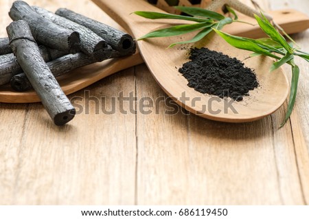 Bamboo charcoal and powder on natural background. Royalty-Free Stock Photo #686119450