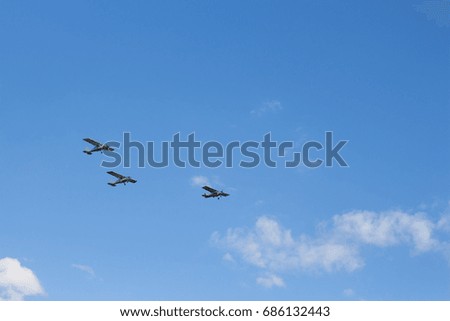 Aircraft flying against the blue sky and white clouds