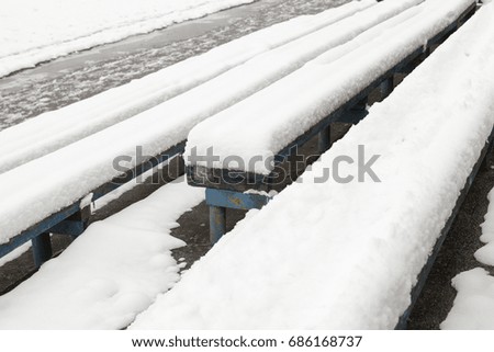 old wooden benches on the stony, covered with snow. Photographs close-up on top. winter