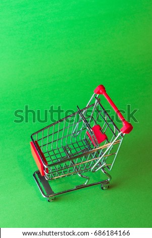 Small shopping cart isolated on green background.