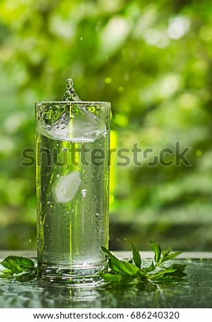 Cool fresh water with ice and mint. Splash in glass. Healthy life concept