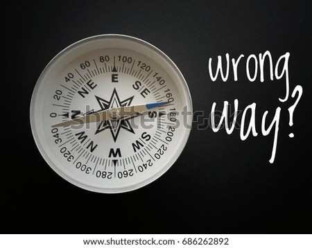 Concept image of Compass and word - Wrong Way? with black background/selective focus/vintage.