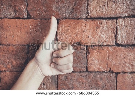 female teen hand shows thumbs up
