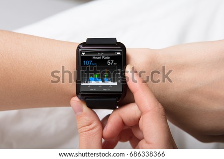 Smart Watch Showing Heartbeat Monitor On Woman's Hand Royalty-Free Stock Photo #686338366