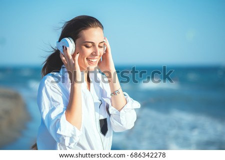 Young woman listen  music at the beach.