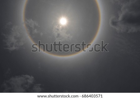 Ray of sunlight and sun halo with thin clouds