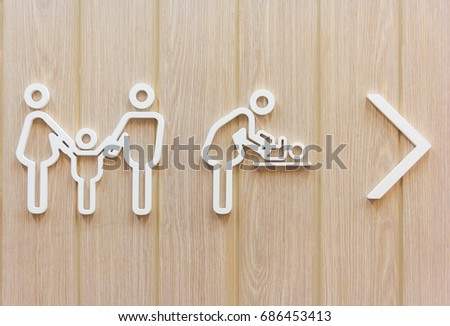 Women with baby symbol, Changing diapers toilet sign on wooden background