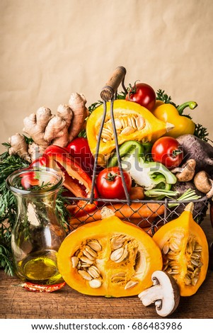 Basket with various autumn seasonal organic harvest  vegetables and pumpkin at wall background, front view.  Autumn food inspiration 