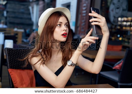A woman with red lips takes pictures of herself on the veranda, Selfie                               