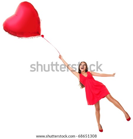 Love concept. Woman flying away with red heart balloon. Funny valentines day image of beautiful cute young woman in red dress. Asian / Caucasian girl isolated on white background in full length.