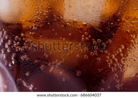 Bubbles and fizz. A cool glass of cola drink with ice