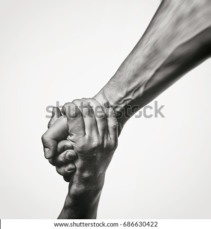 Concept of salvation. Black and white image of the hands of two people at the time of rescue (help). Royalty-Free Stock Photo #686630422