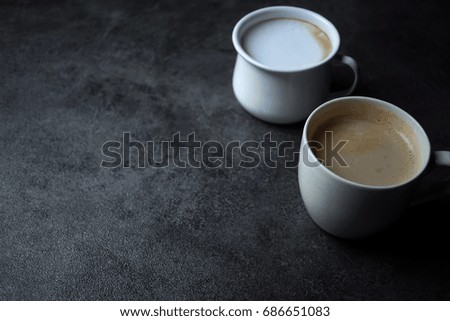 two cups of coffee and blank space on dark table background