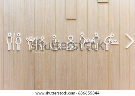 Symbols for toilet Men, women, unisex. Dads with daughters and mothers with sons. Disabled seniors and children, women with baby symbol, Changing diapers toilet sign on wooden background