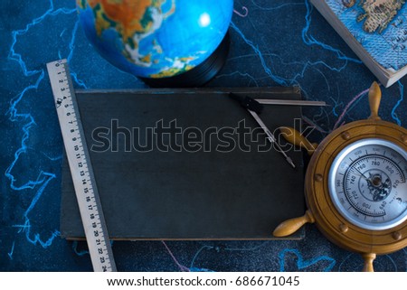 Still life globe on a black matte background with a barometer