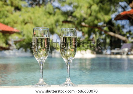 Glasses of champagne in the pool