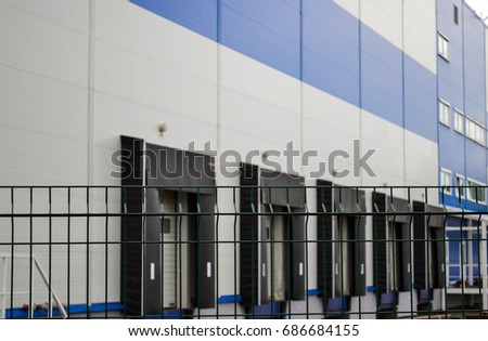 Large distribution warehouse in the background behind a latticed fence Royalty-Free Stock Photo #686684155