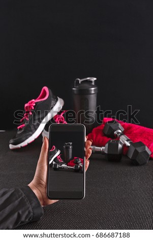 Sport equipment photographing on mobile phone. Smartphone screen with fitness tools image