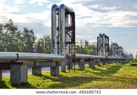 Overground heat pipes. Pipeline above the earth conducting heat for heating city Royalty-Free Stock Photo #686688742
