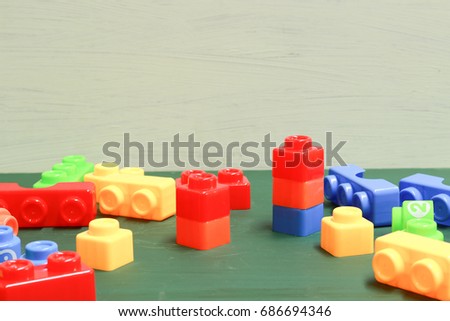 plastic bricks at the table.  Early learning. stripe background. Developing toys