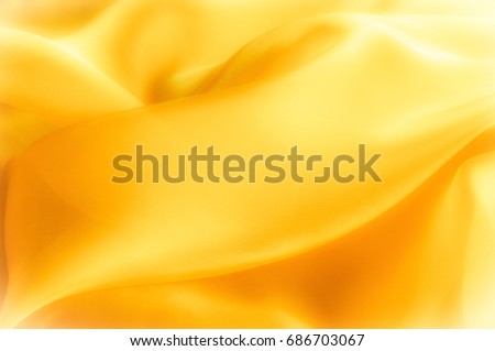 The photo is blurred. Texture, background, pattern. Yellow silk fabric. Abstract background of luxury Yellow fabric or liquid wave or wavy grunge texture. The whole background. Royalty-Free Stock Photo #686703067