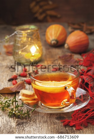 autumn tea with ginger, lemon and thyme on old wooden background