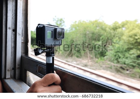 Action camera taking a picture of nature landscape through windows of the train.