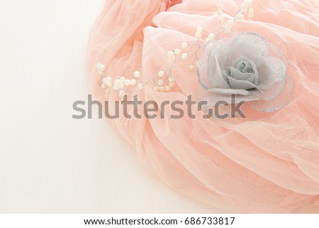 Vintage tulle pink chiffon dress on wooden white table. Wedding and girl's party concept.