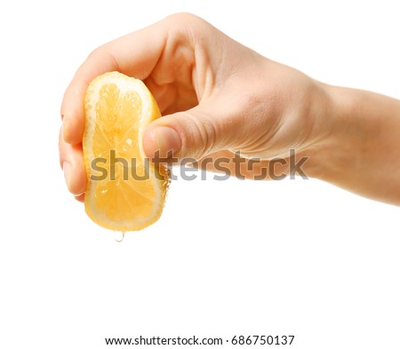 Female hand squeezing half of lemon on white background Royalty-Free Stock Photo #686750137