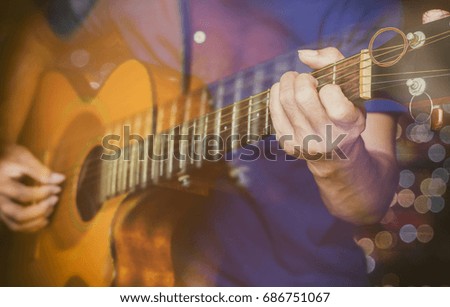 a man playing acoustic guitar with filter color tone and motion blur and bokeh background.