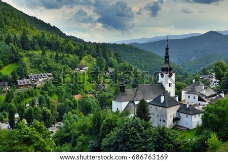Summer in Slovakia. Old mining village. Historic church in Spania dolina. Summertime colored country before storm. Royalty-Free Stock Photo #686763169