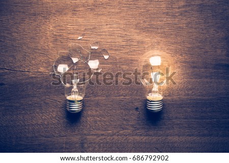 Broken and Glowing light bulb comparison concept, problem and solution, failure and success, learning from mistake Royalty-Free Stock Photo #686792902